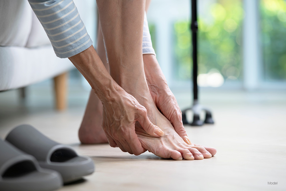 Woman holding her foot in pain